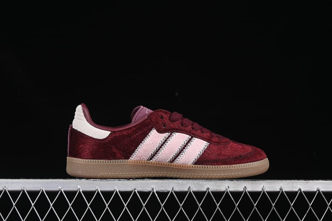 Side profile of a burgundy sneaker with pale pink stripes and gum-colored sole
