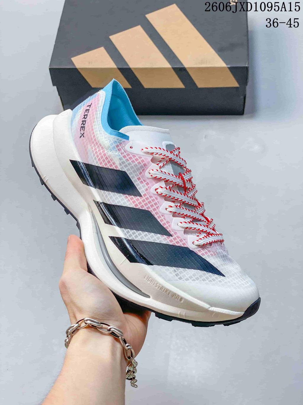 Side view of a white Adidas Terrex shoe with pink and blue details