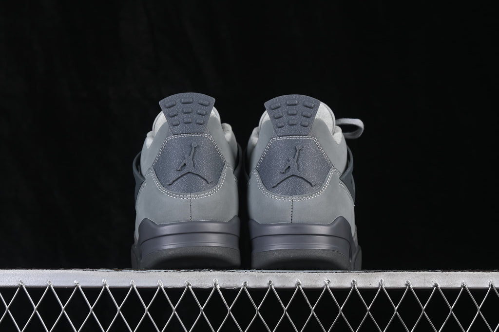 Rear view of grey Air Jordan 4 Retro SE sneakers showing heel panels and pull tabs.