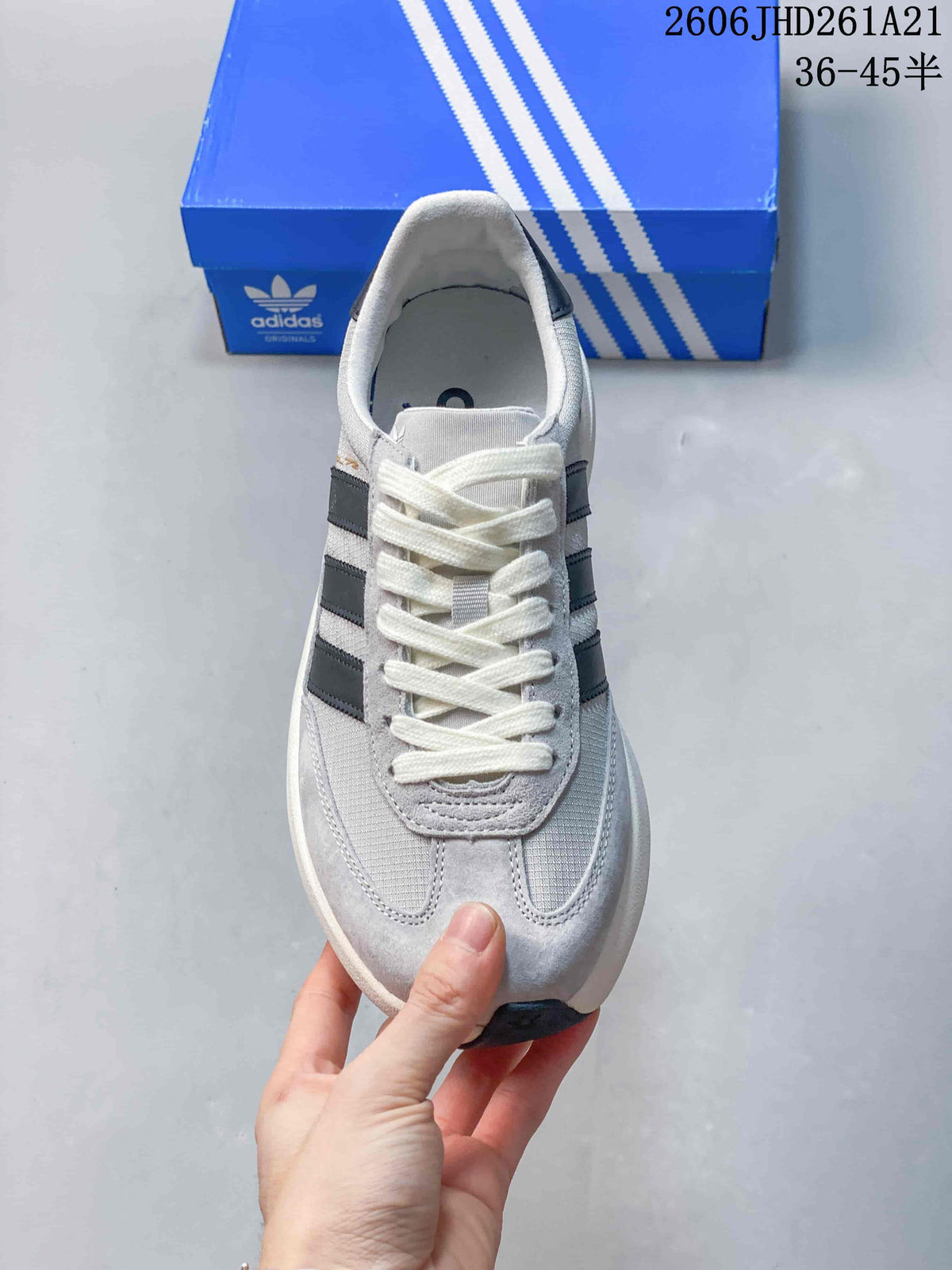 Front view of a grey lace-up sneaker with dark side stripes