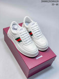 Pair of white Gucci low-top lace-up sneakers with green-and-red side stripes and chunky soles
