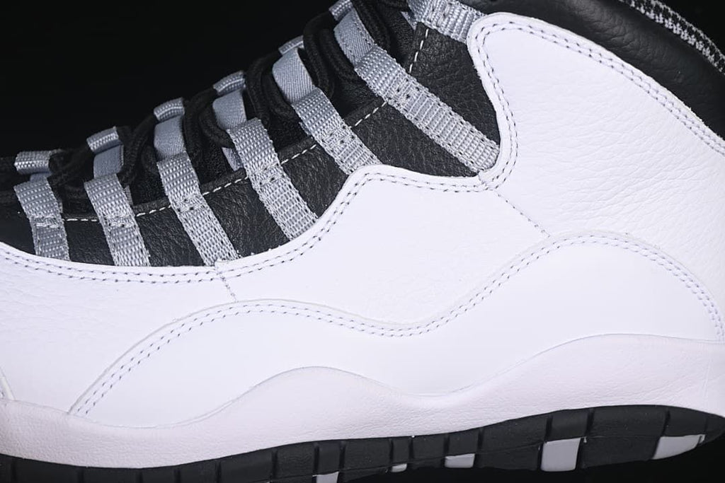 Close-up of the white side panels, grey lace loops, and outsole