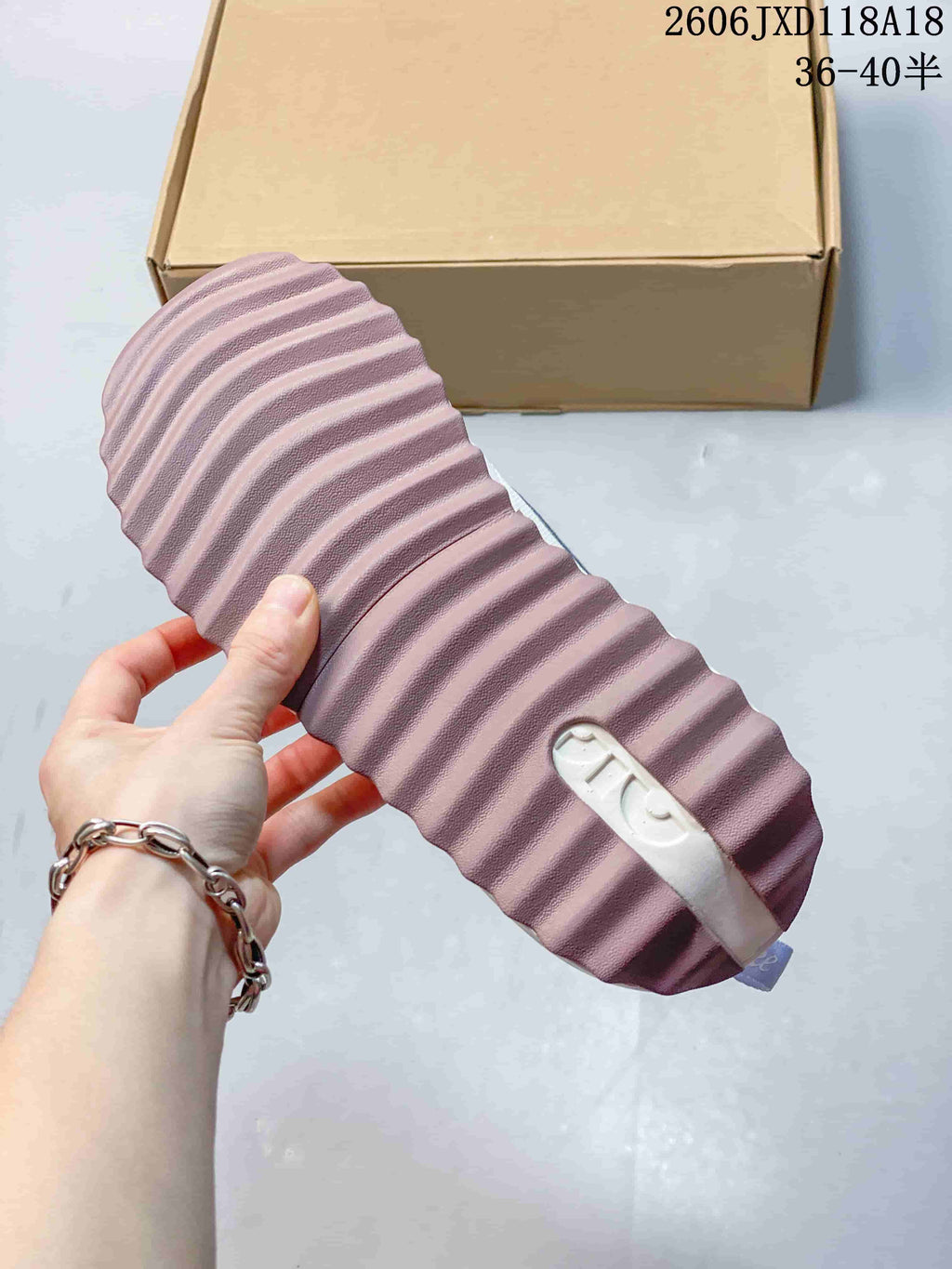 Underside of the sneaker showing a ridged mauve outsole.