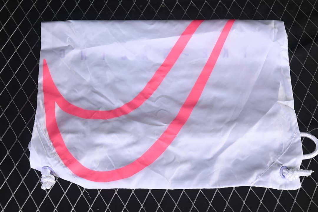 White drawstring shoe bag with a large bright pink Swoosh.