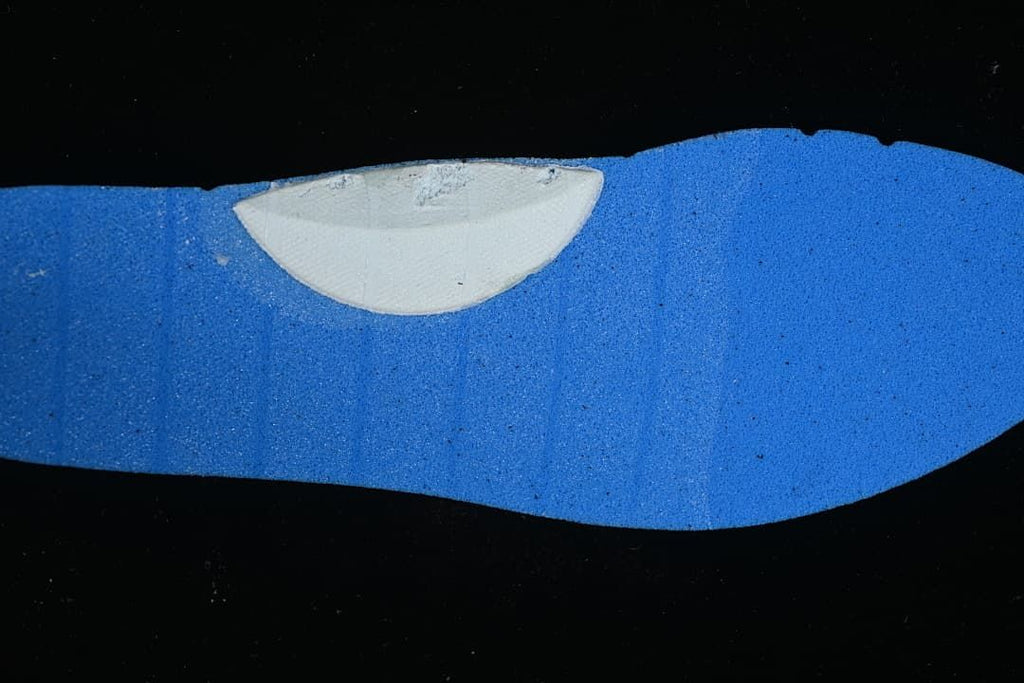 Close-up of a blue shoe insert with a pale curved detail.