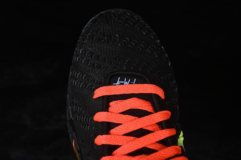 Top view of the black shoe with bright orange-red laces.