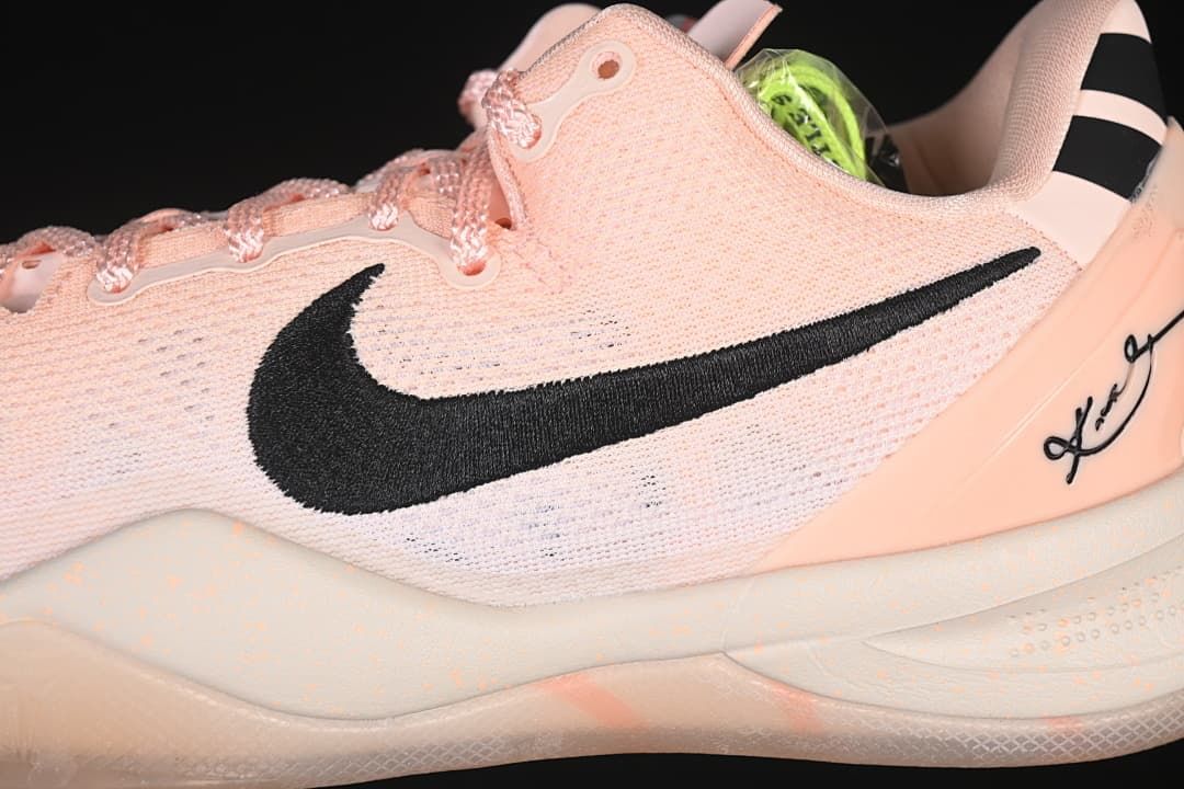 Side close-up of pink upper, black Swoosh, and heel signature detail