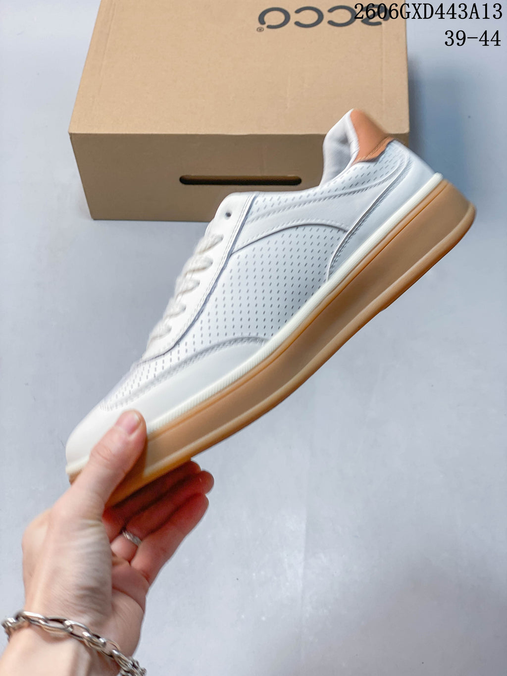 Side view of the white perforated ECCO sneaker with tan heel and gum-colored sole.