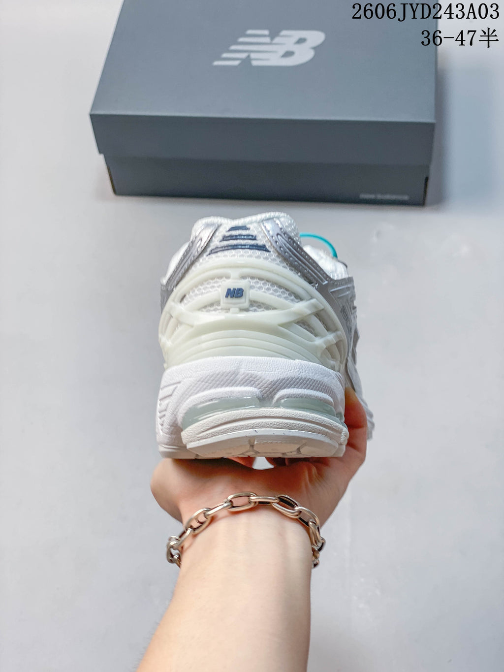 Rear view showing the heel and sole of a white sneaker
