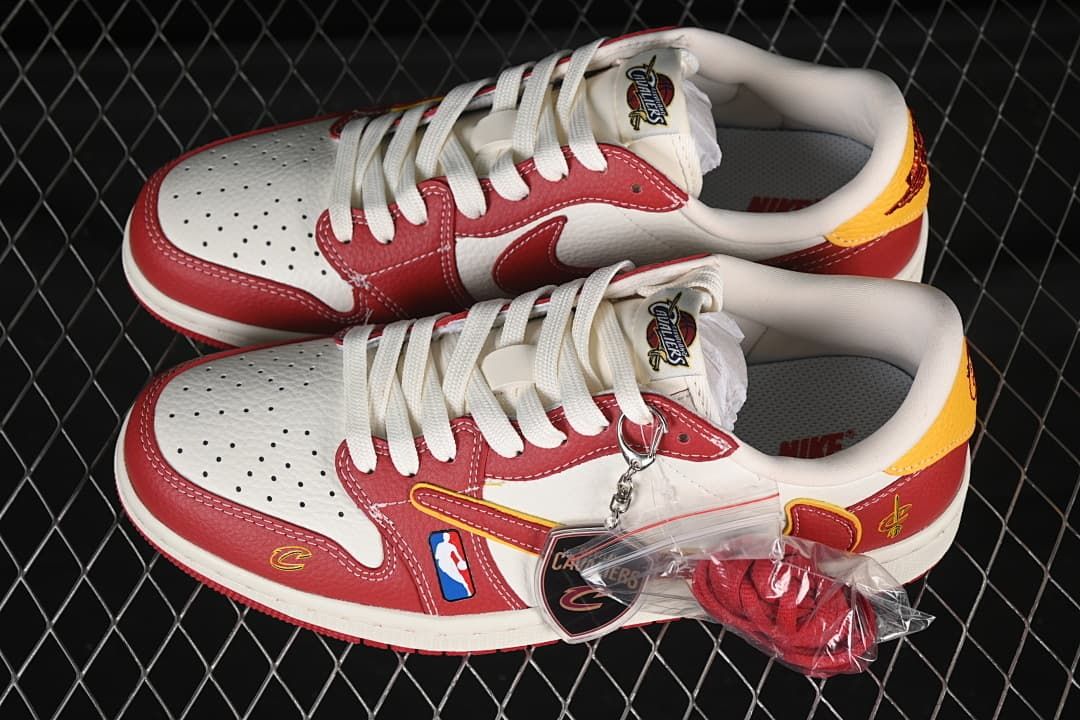 Pair of white and red low-top sneakers with yellow accents, team-themed tags, and extra red laces