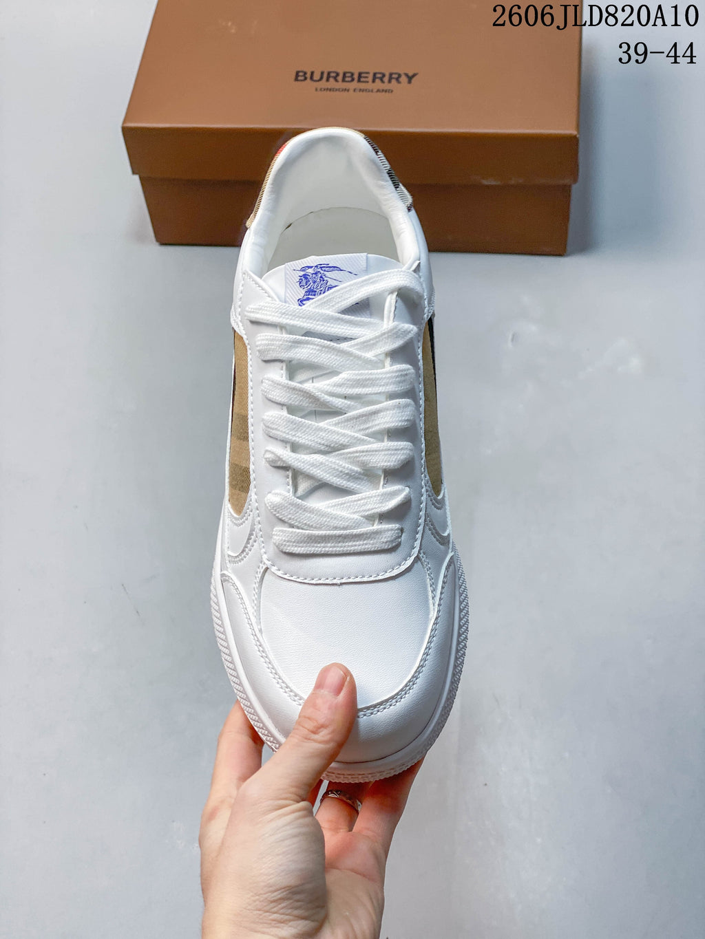 Top view of a white lace-up sneaker with check-pattern side details