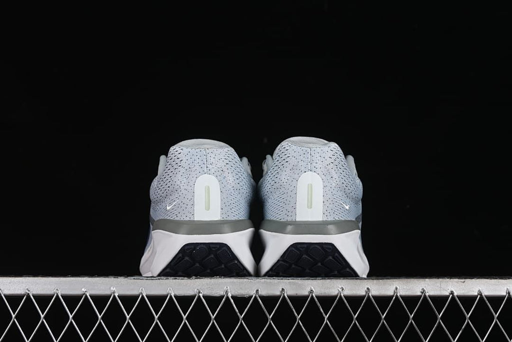 Rear view of both shoes showing the heel counters and outsole edges