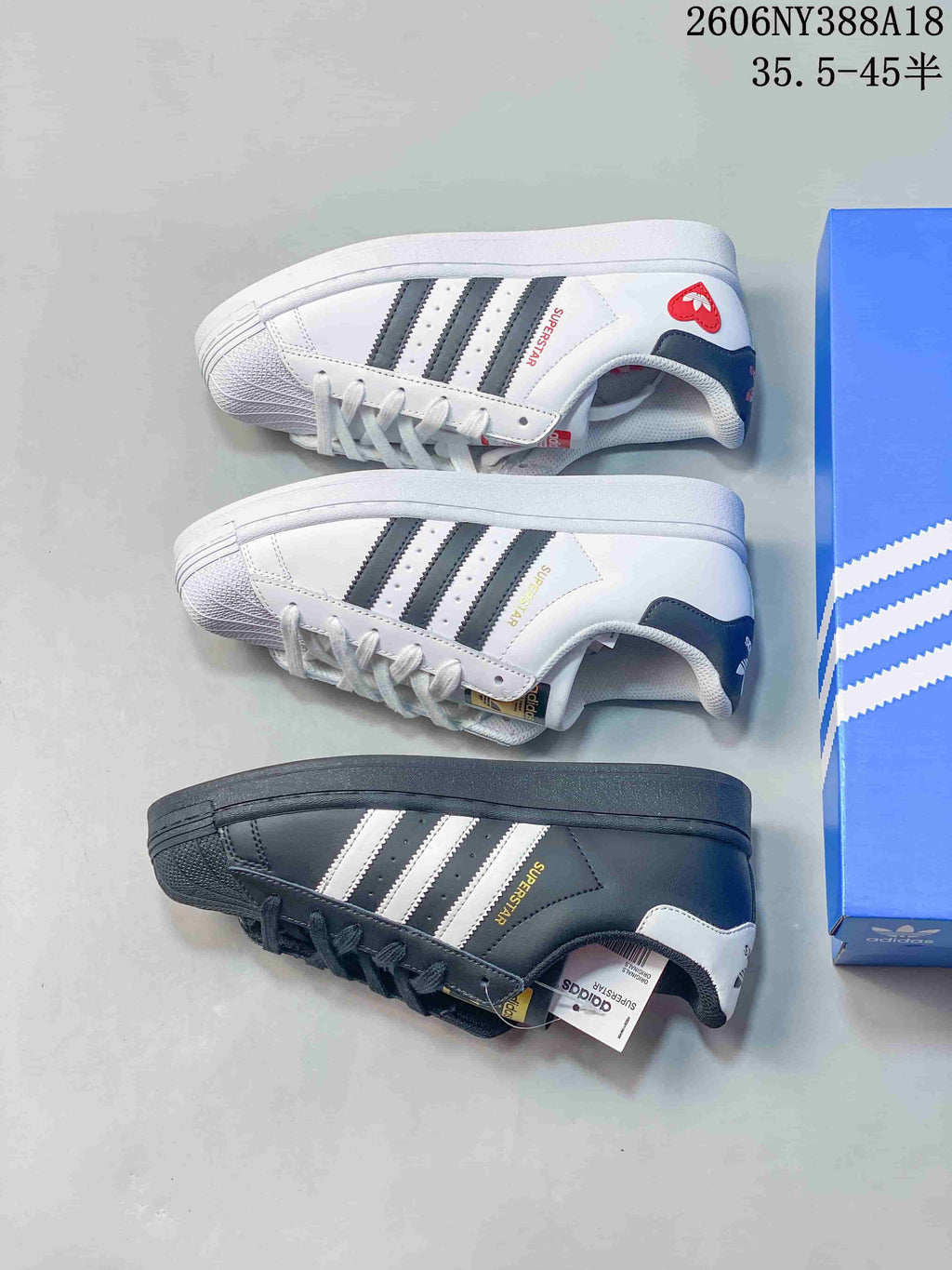 Three Adidas Superstar sneakers in white and dark color variations, shown from the side.