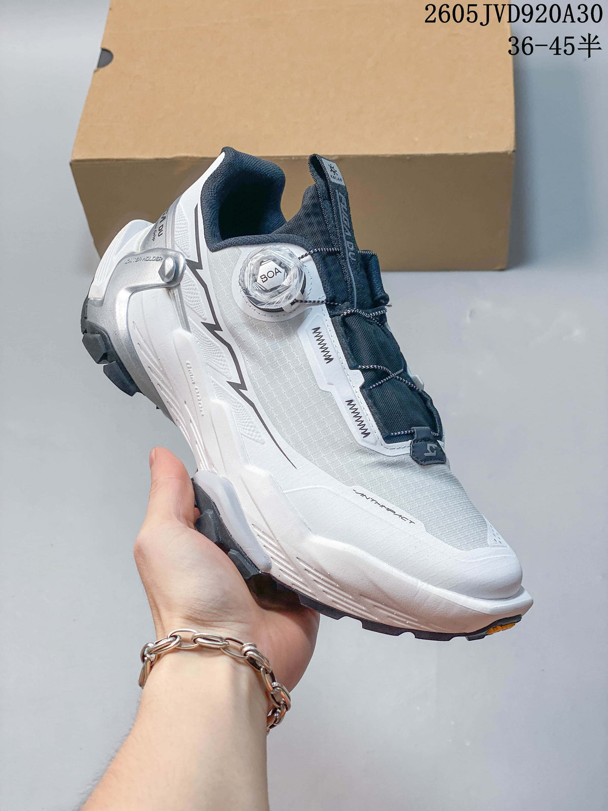 Angled side view of the white trail shoe with BOA dial closure and dark outsole.