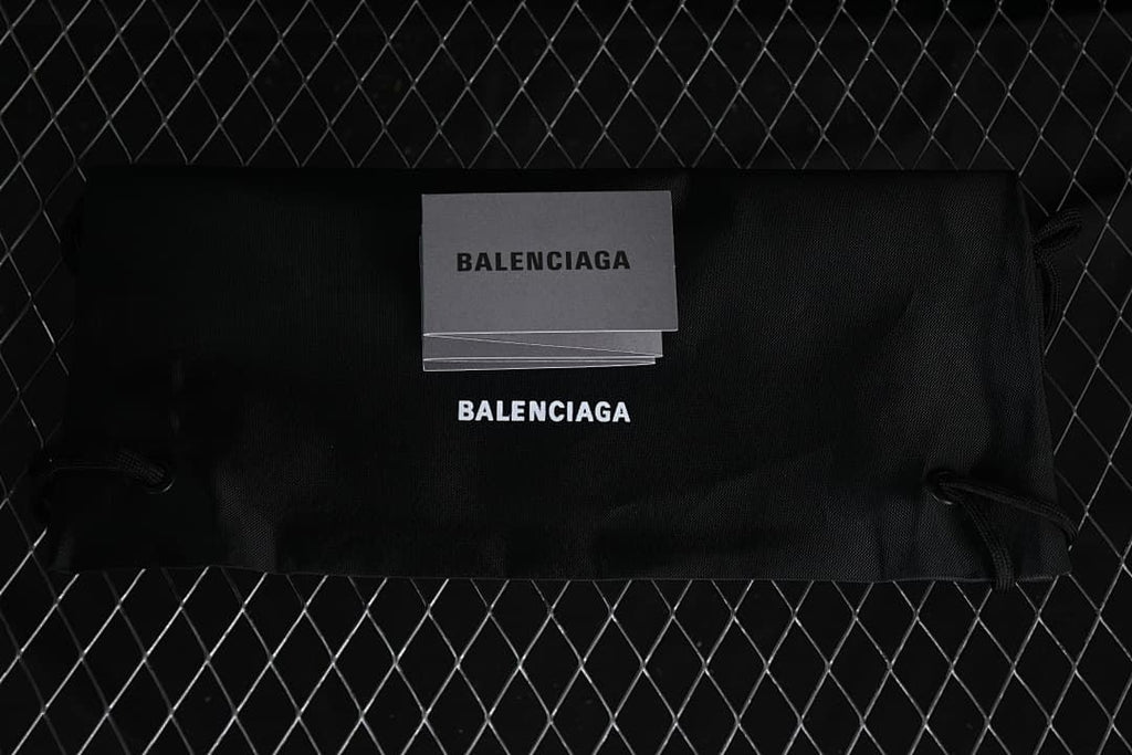 Black Balenciaga-branded shoe bag and printed cards.
