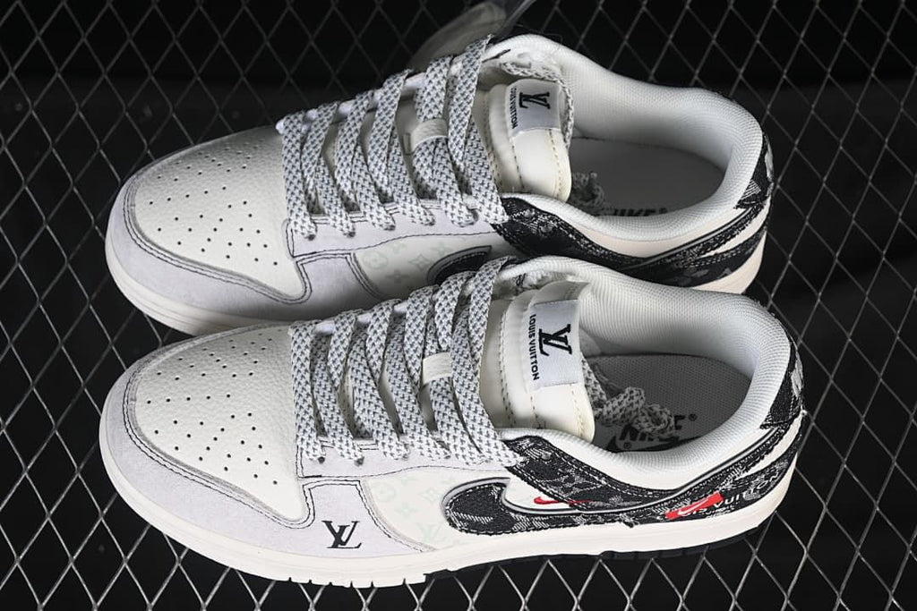 Top view of a pair of white and black low-top sneakers with patterned laces and graphic overlays