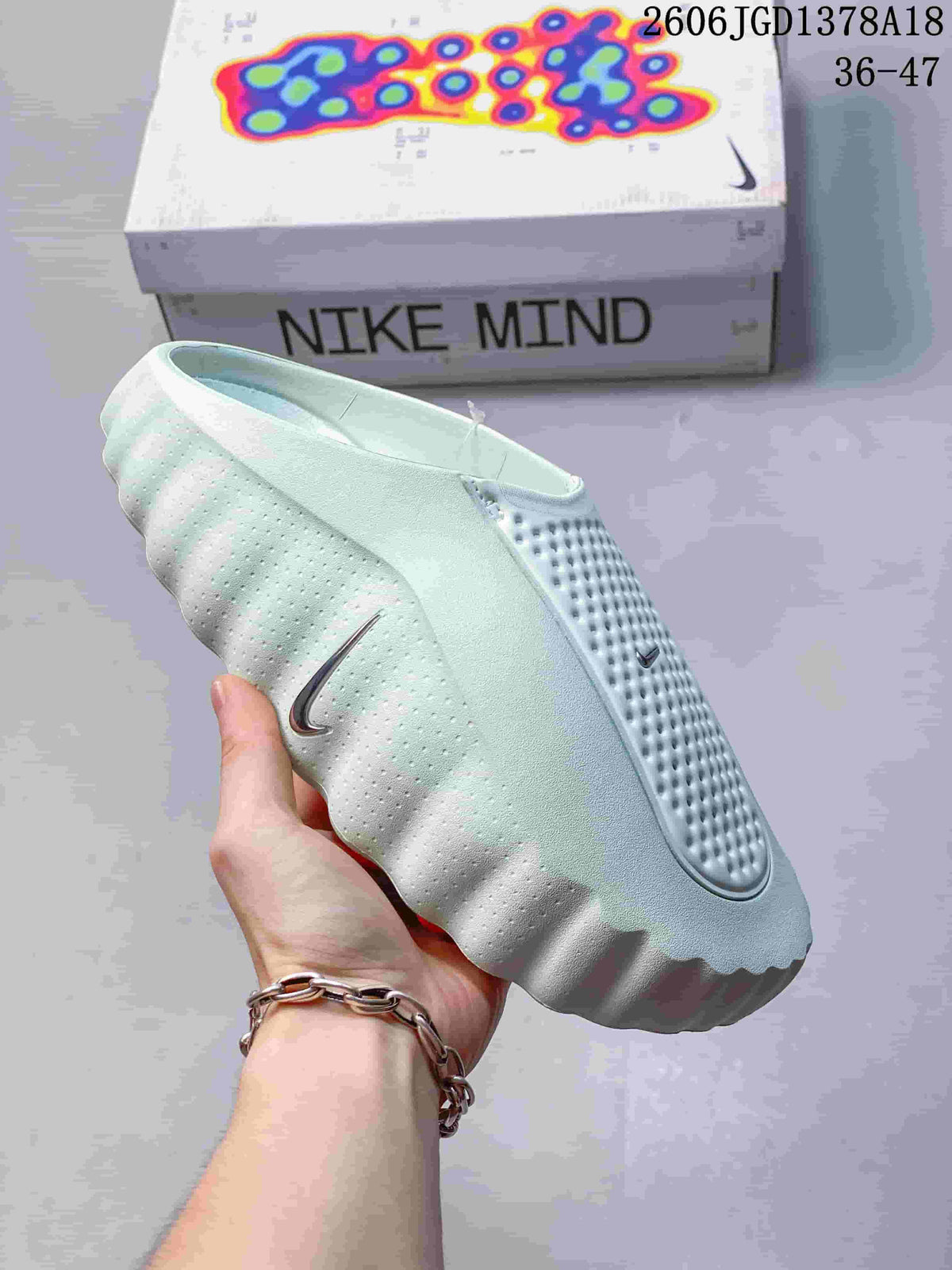 Angled side view of a pale mint Nike Mind closed-toe slide