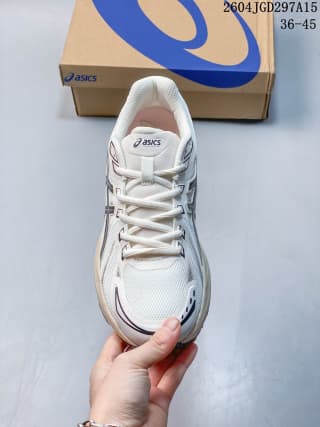 Front view of the white ASICS Gel-Flux CN shoe showing the laces, mesh-textured toe area, and dark side detailing.
