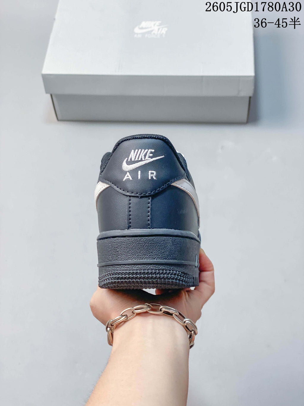 Rear view of a dark gray Nike Air Force 1 Low sneaker with Nike Air branding on the heel.