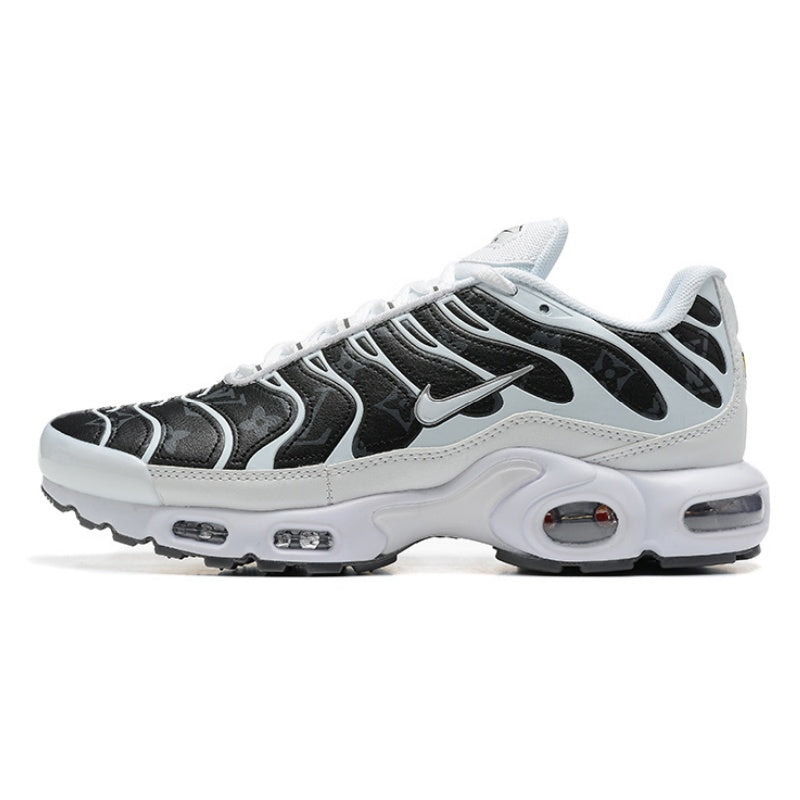 White and black Nike Air Max Plus sneaker with a patterned dark upper.
