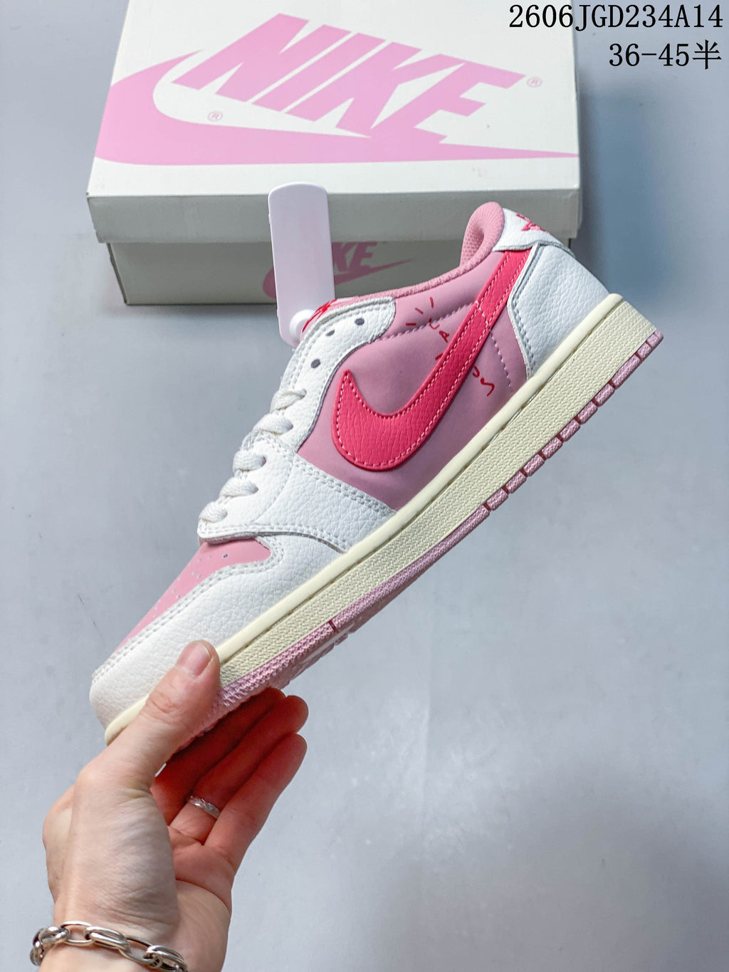 Side view of the pink and white low-top sneaker with a bright-pink Swoosh