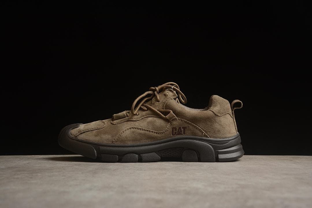 Side profile of a brown low-top CAT shoe with a dark outsole.