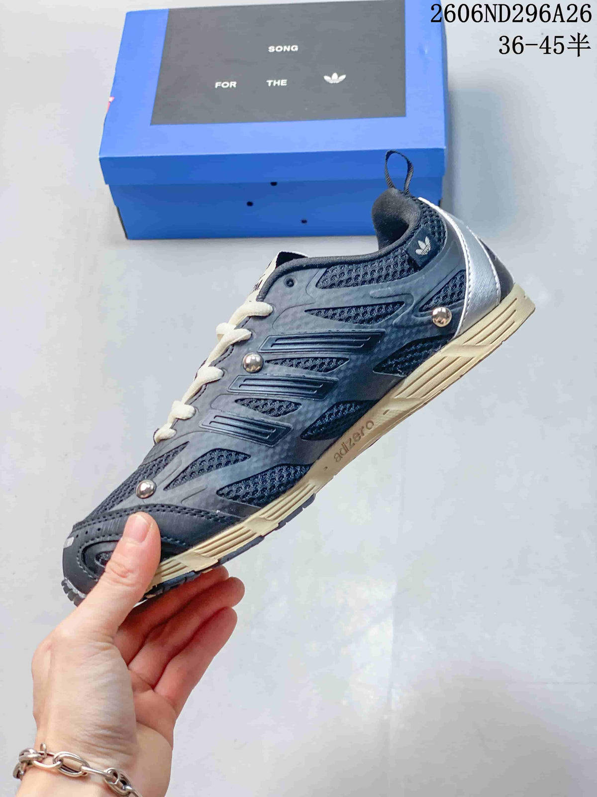 Side view of a dark gray low-top sneaker with layered overlays and three-stripe detailing