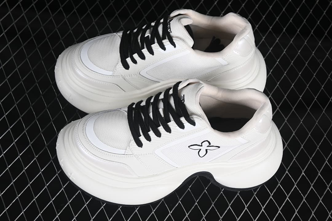 Pair of white low-top sneakers with black laces and sculpted soles