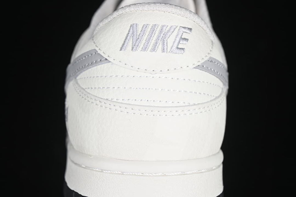 Rear view of the sneaker showing embroidered Nike lettering and grey heel details.