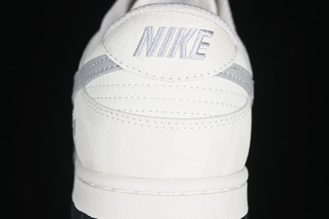 Rear view of the sneaker showing embroidered Nike lettering and grey heel details.