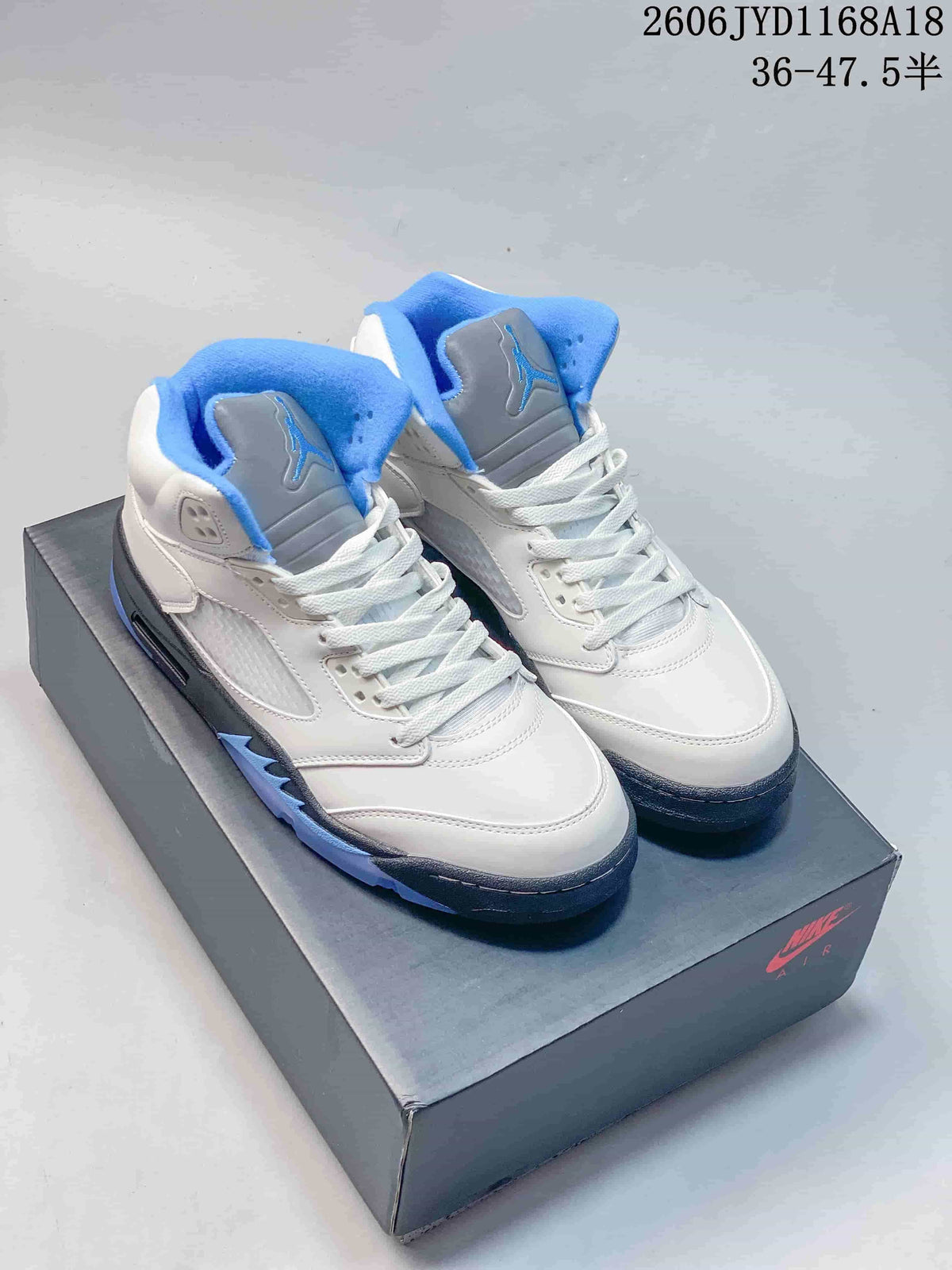 Pair of white Jordan AJ5 high-top sneakers with blue and gray details
