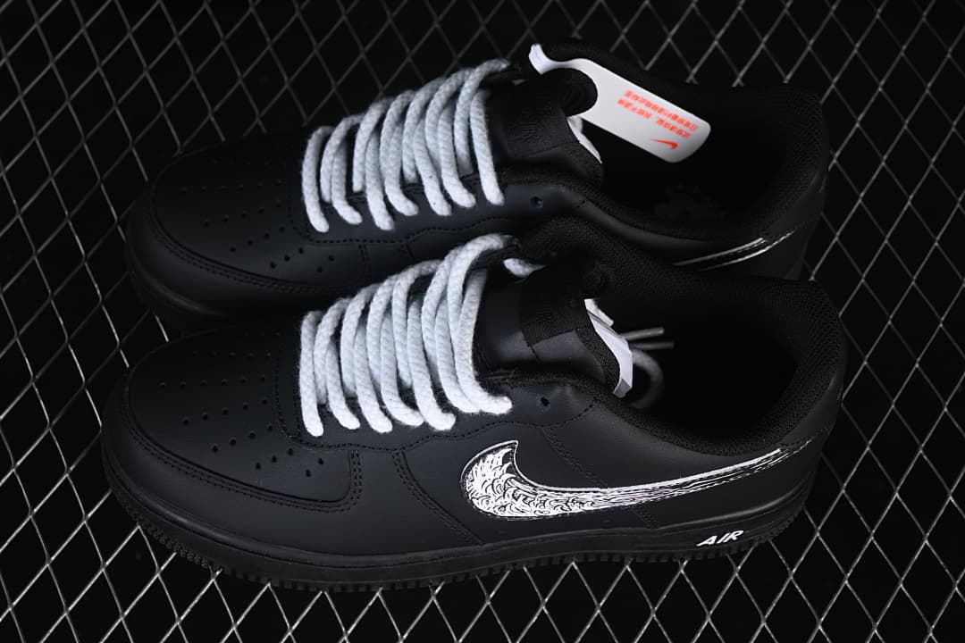 Pair of black low-top sneakers with thick white laces and illustrated Swoosh graphics
