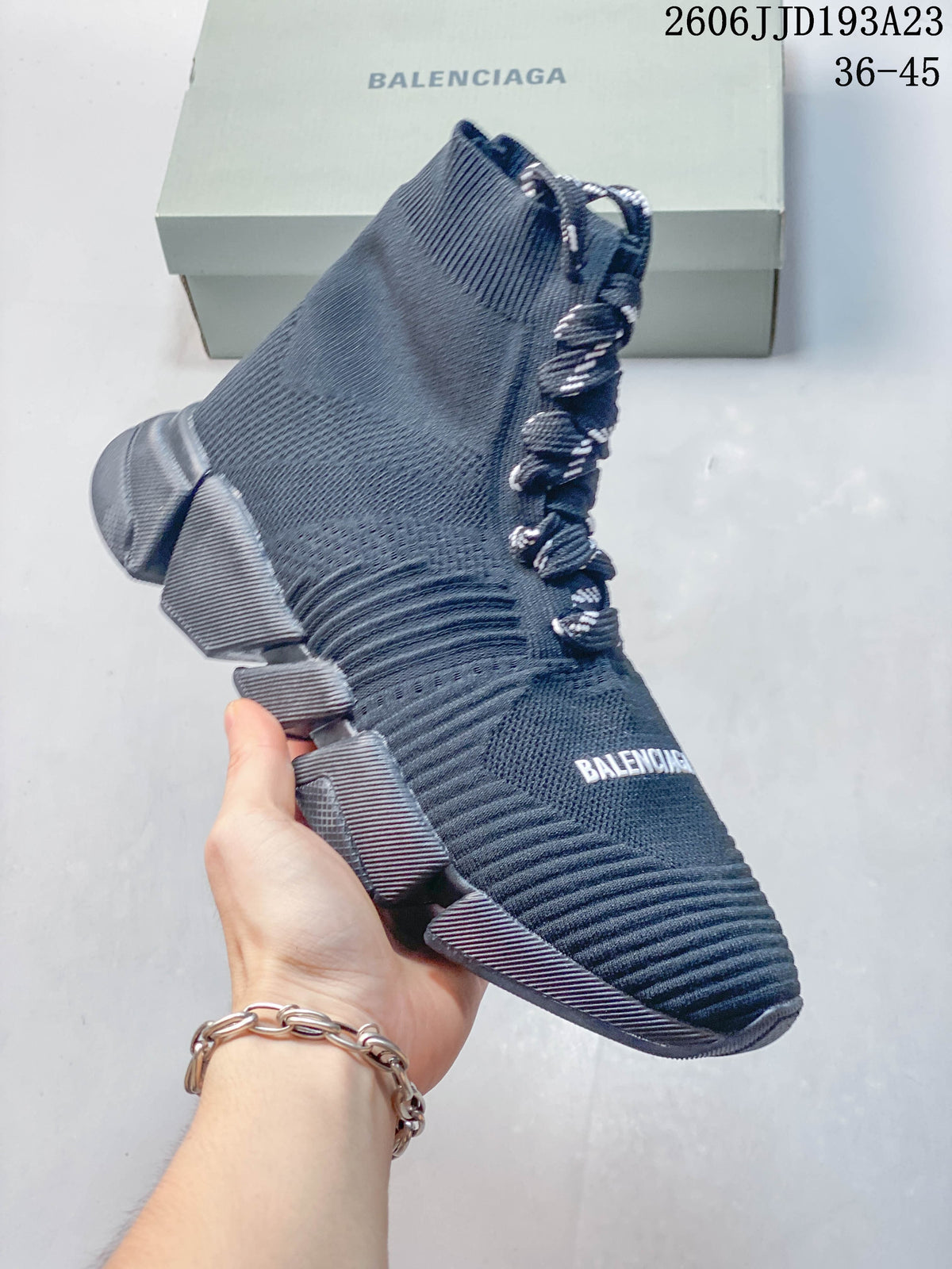 Angled view of a navy sock-style sneaker with a chunky segmented sole