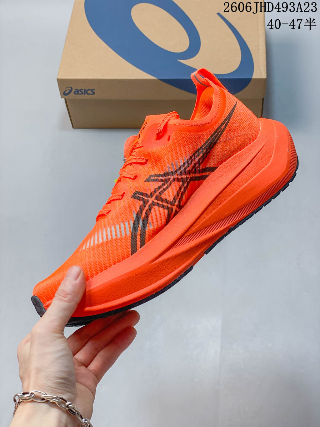Side view of an orange running shoe with dark side graphics