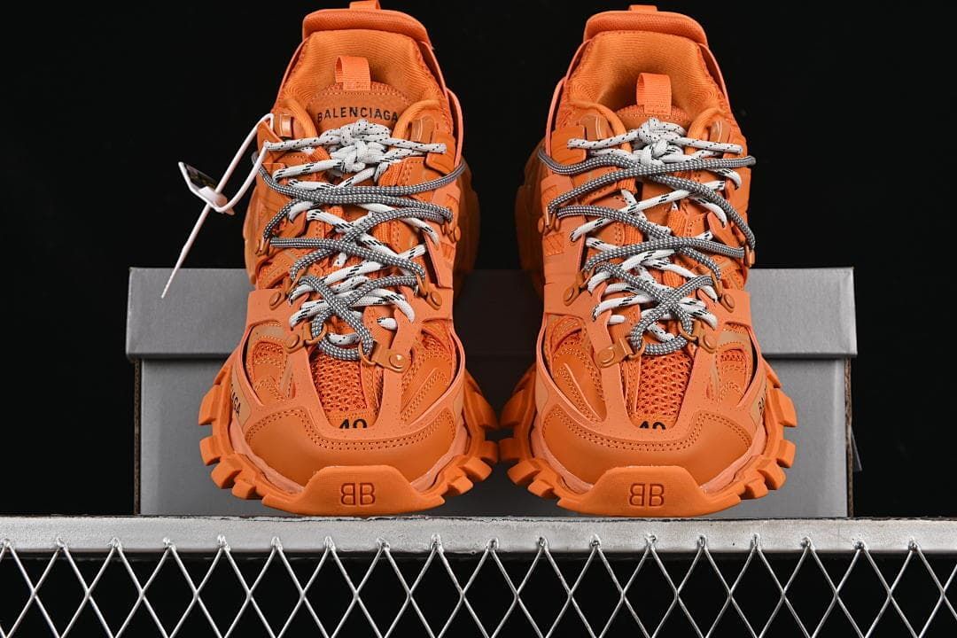 Front view of the orange sneaker pair on the box