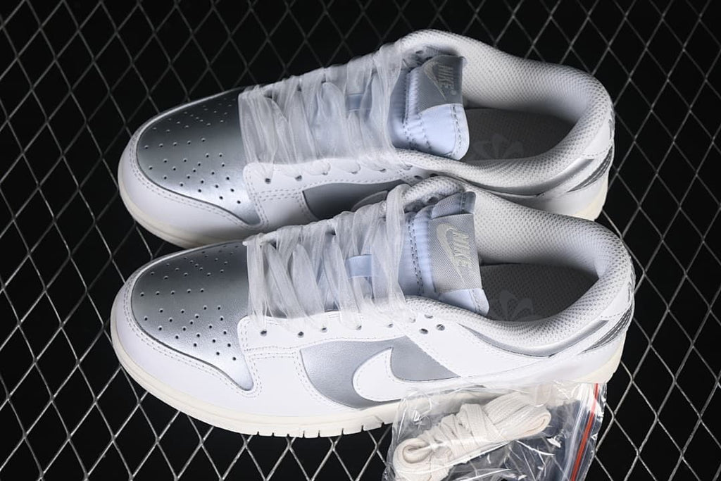 Pair of white and silver low-top sneakers with an additional lace set pictured