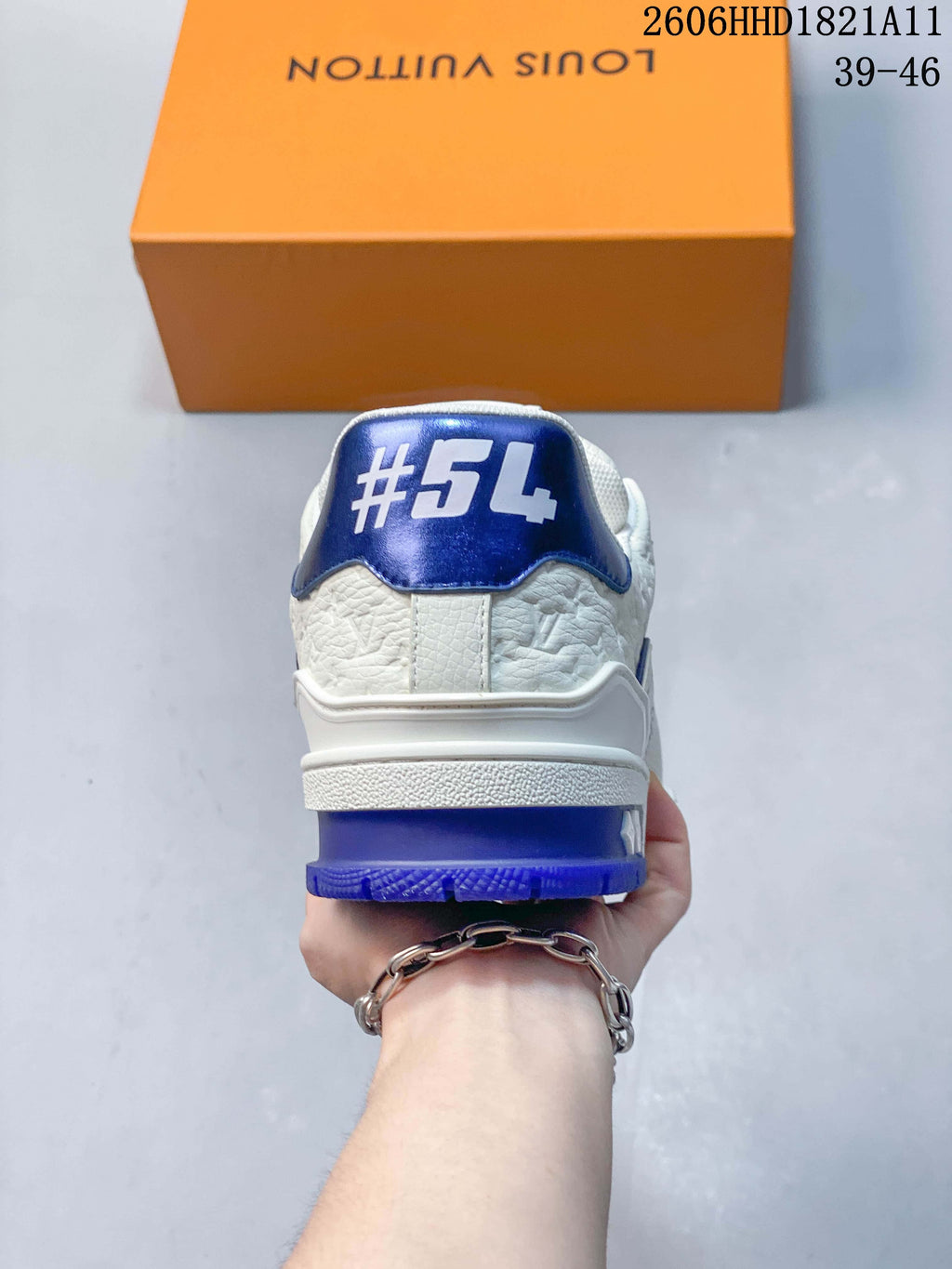 Rear view of a white sneaker with a blue heel panel and outsole.