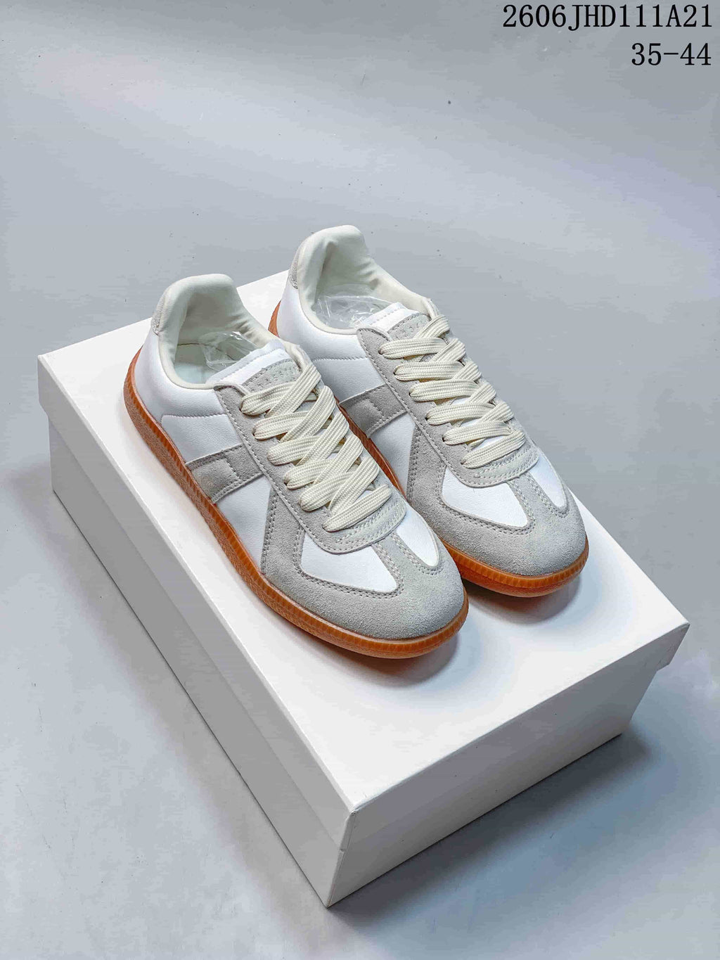 Pair of white and grey low-top sneakers with cream laces and gum-colored soles