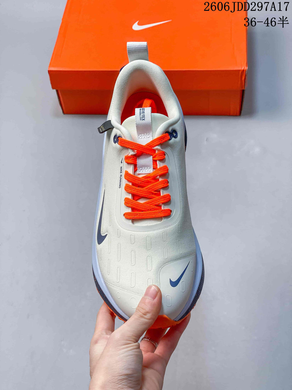Top view of a Nike InfinityRN 4 shoe with bright orange laces and gray upper.