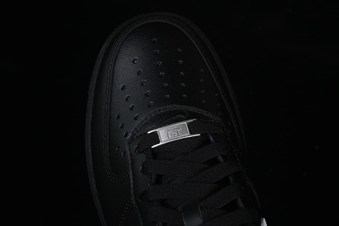 Top close-up of the perforated toe, black laces, and metal lace tag