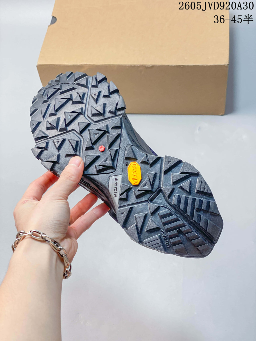 Close-up of the trail shoe outsole showing its geometric lug pattern and MEGAGRIP marking.