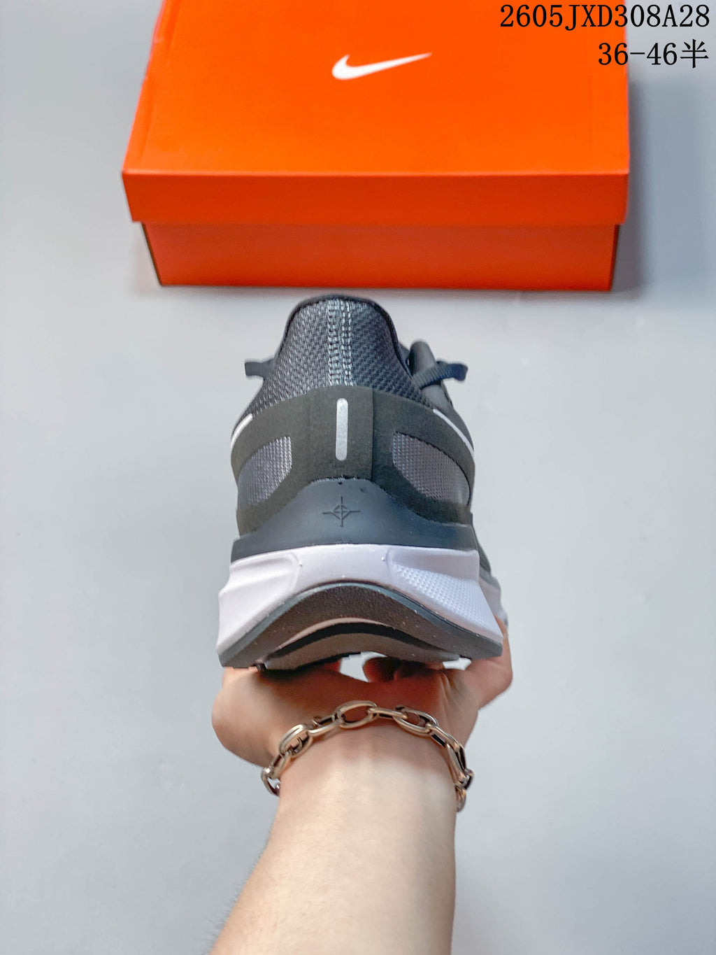 Rear view showing the structured heel and white midsole of a gray running shoe.
