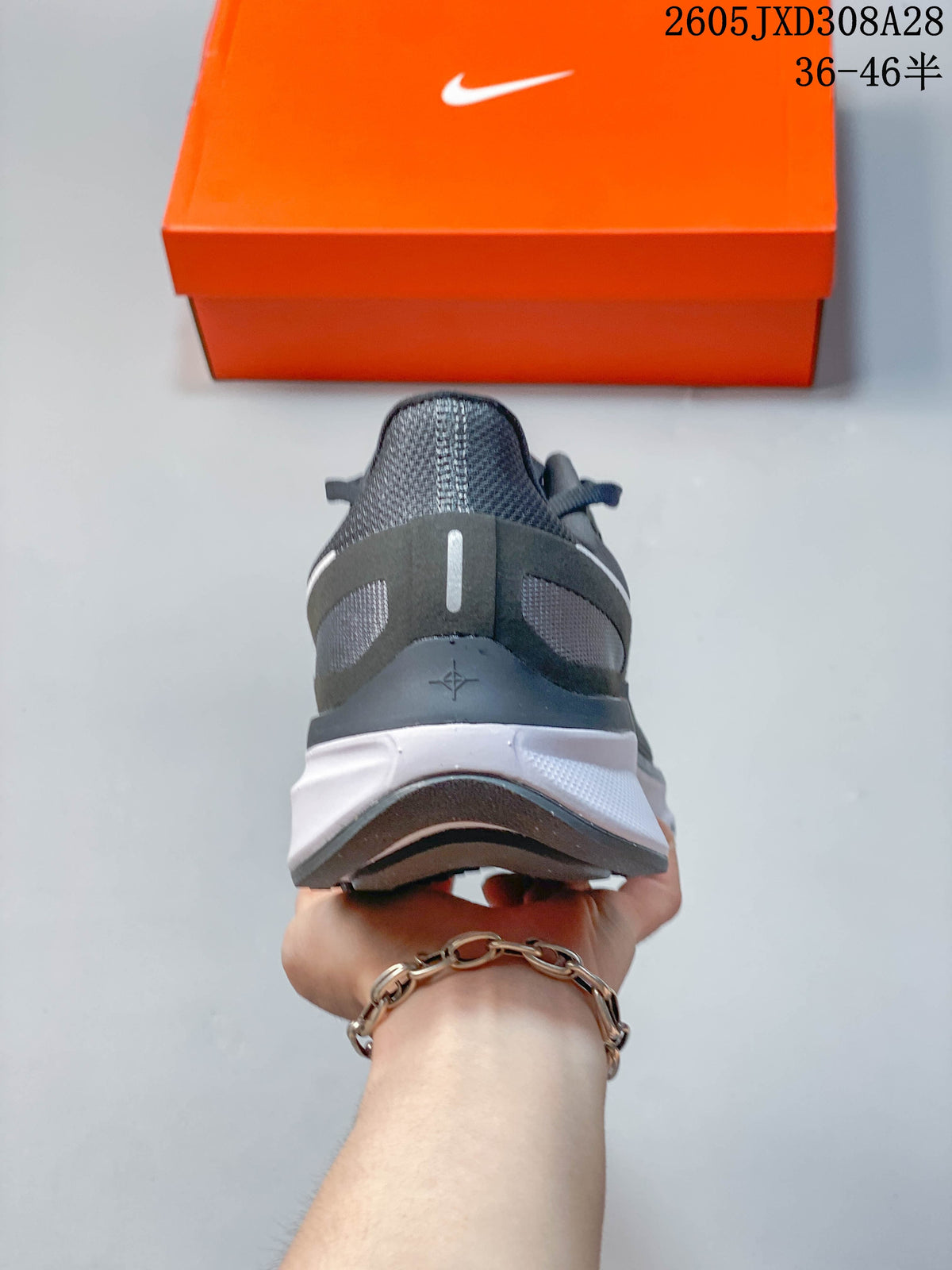 Rear view showing the structured heel and white midsole of a gray running shoe.
