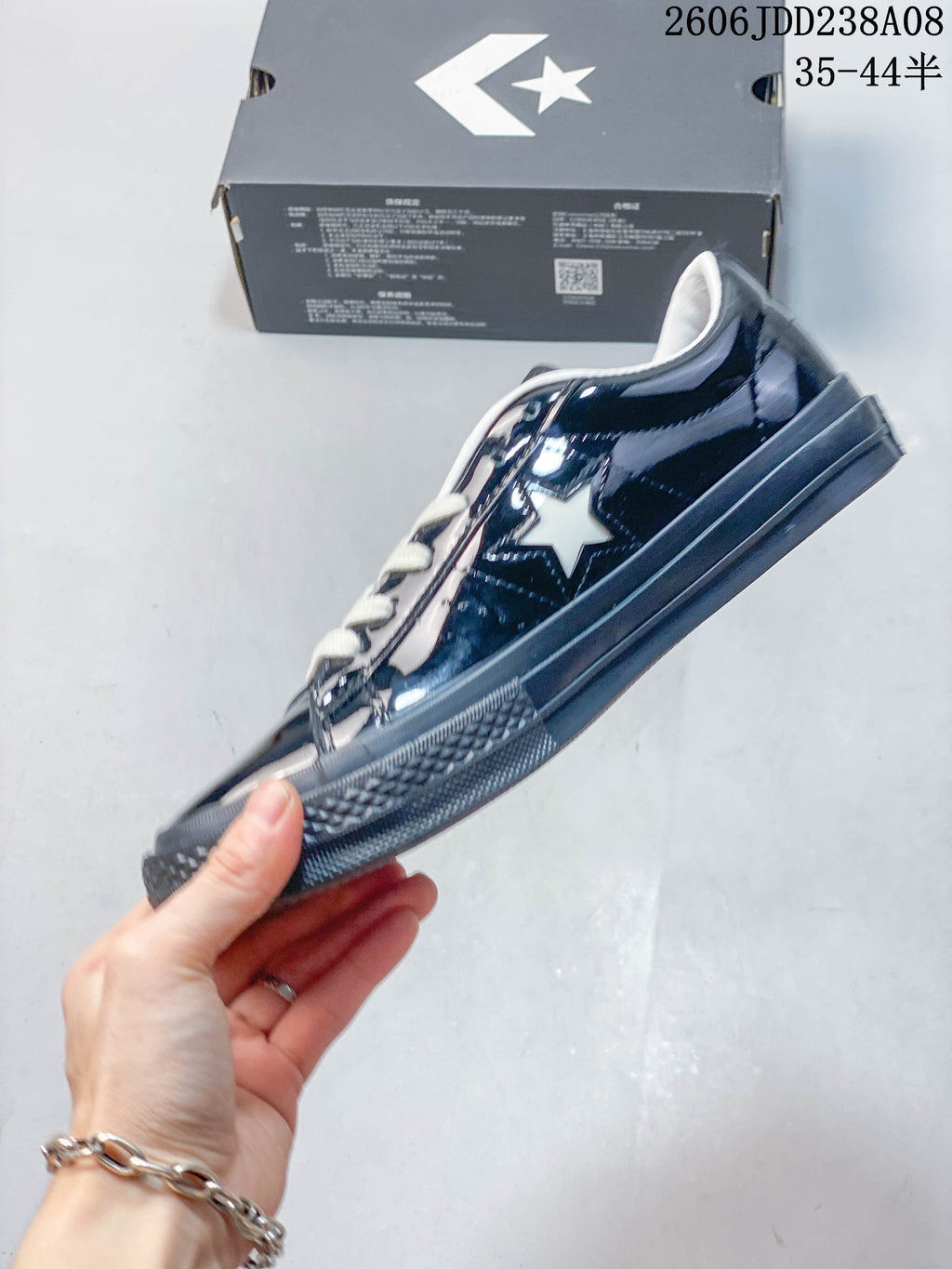 Side profile of a glossy navy Converse One Star low-top sneaker with a white star accent