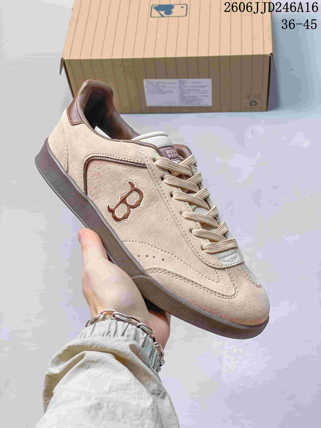 Close-up of a beige Boston Red Sox sneaker with brown side graphics and a dark sole.