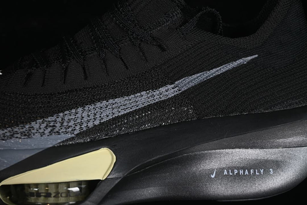 Close-up of silver Swoosh, black upper, and Alphafly 3 sole marking