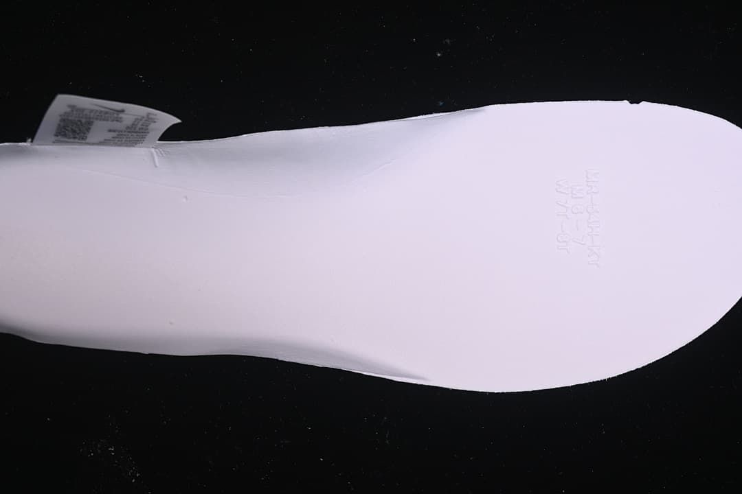 Close-up of the underside of a white shoe insert with embossed markings