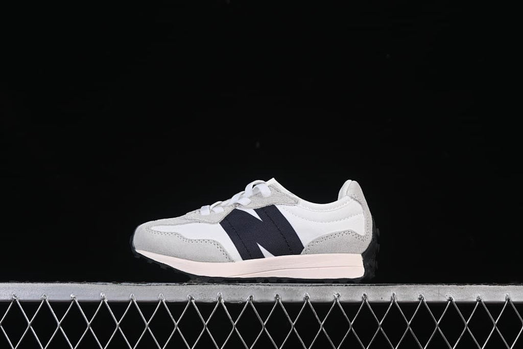 Side view of a white and light gray New Balance 327 sneaker with navy accent.