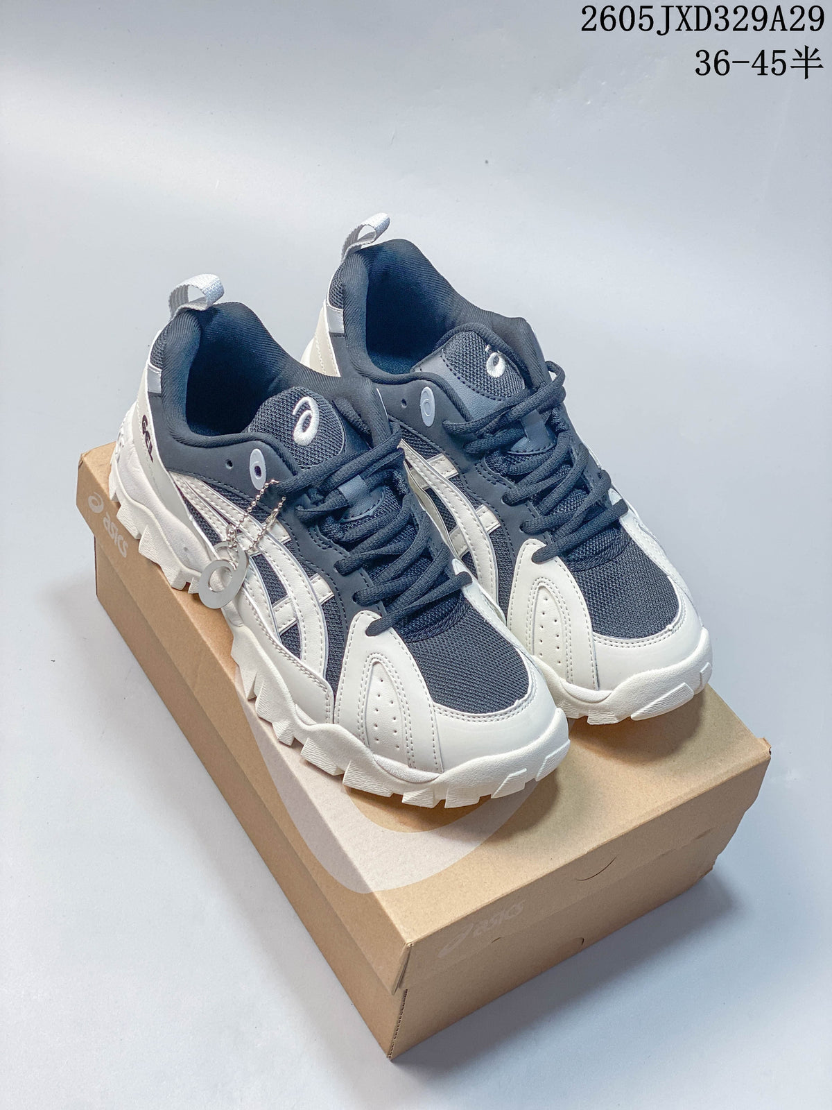 Pair of navy and white Onitsuka Tiger low-top sneakers with contrasting panels and chunky outsoles.