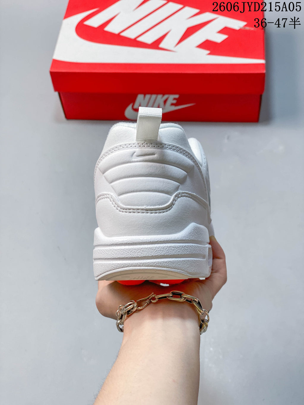 Rear view of the white sneaker showing the heel and pull tab
